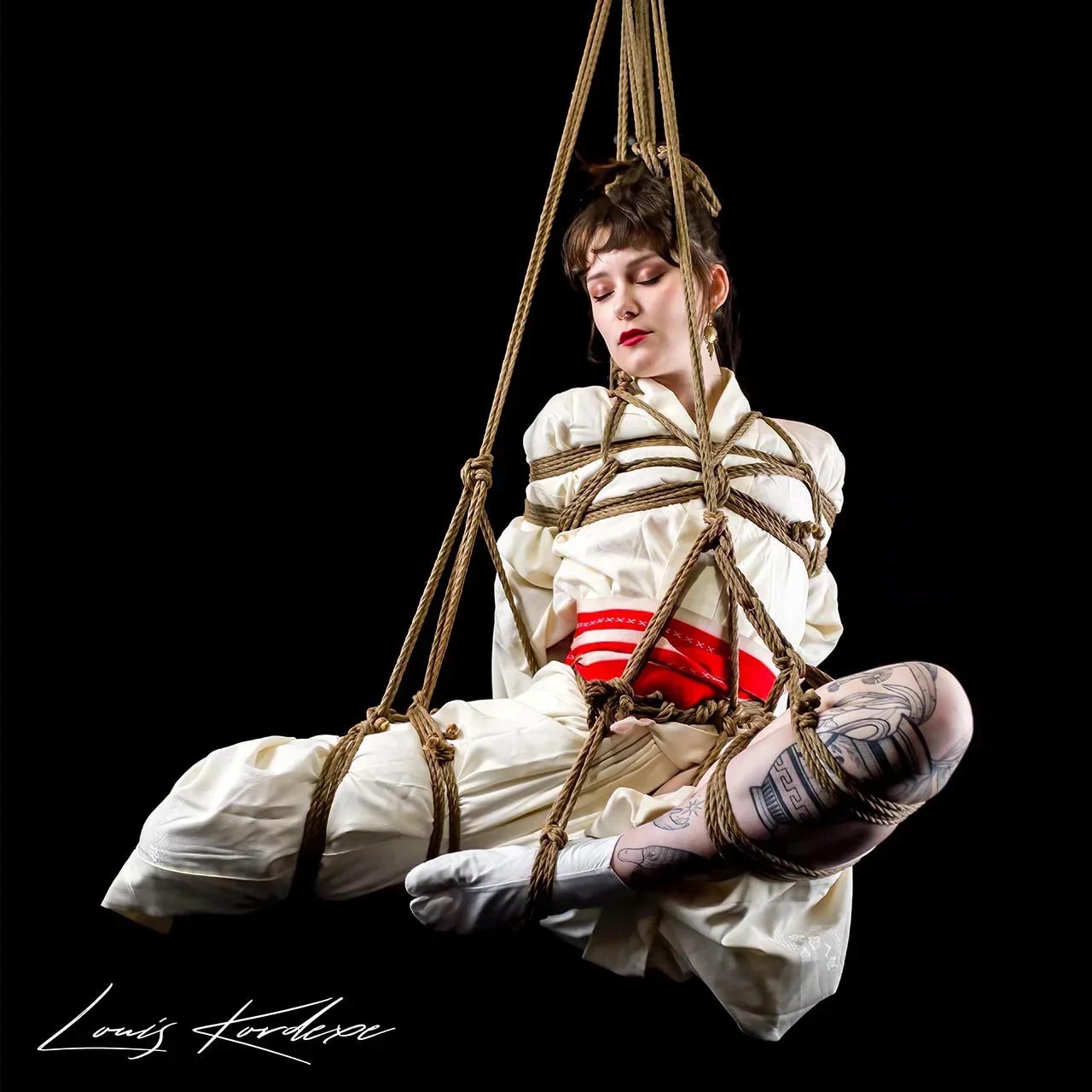 An artistic shibari geibaku tie by Louis Kordexe, focusing on the visual body and aesthetic rope patterns in a Tokyo studio.