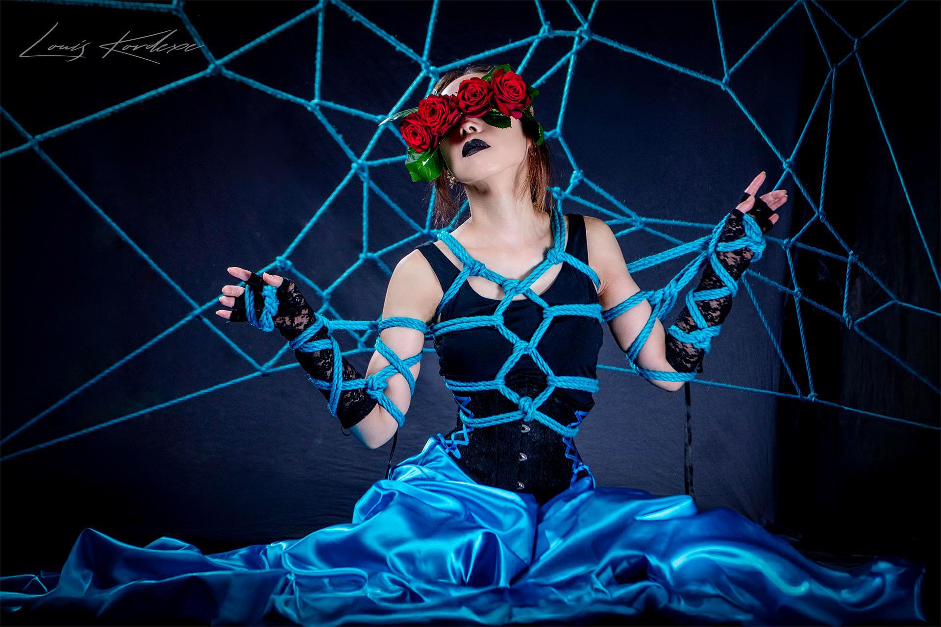 An artistic shibari geibaku tie by Louis Kordexe, focusing on the visual body, lighting and intricate rope geometry in a Tokyo studio.